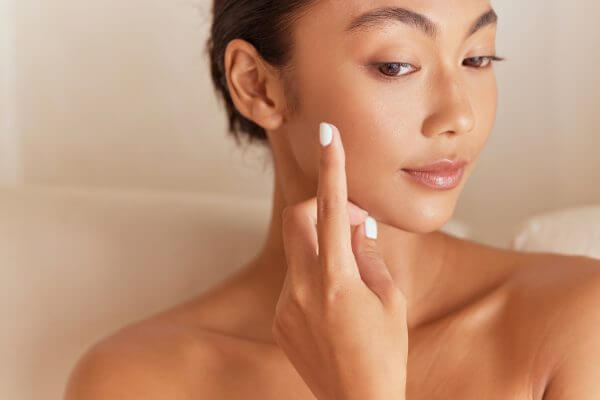 beauty skincare. woman applying moisturizer to her face for skincare routine