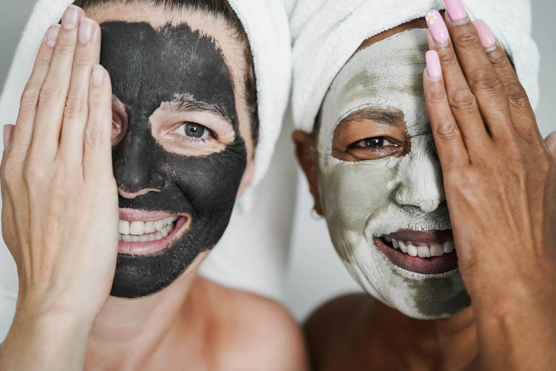 multiracial senior women doing beauty treatment using skin mask body care concept focus on right female face