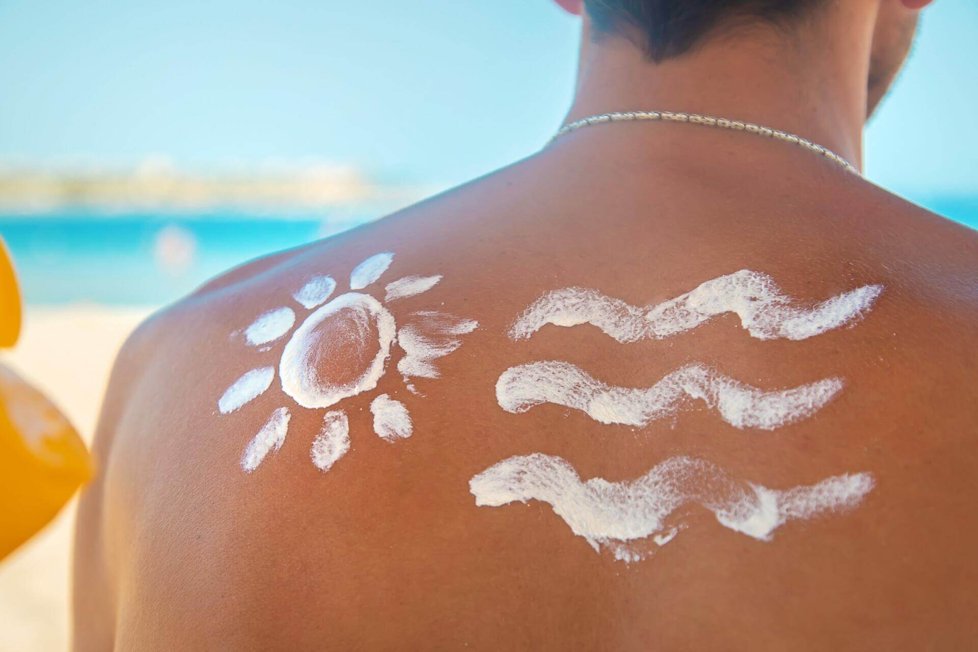 the girl on the beach applies sunscreen to the skin of a man. selective focus.