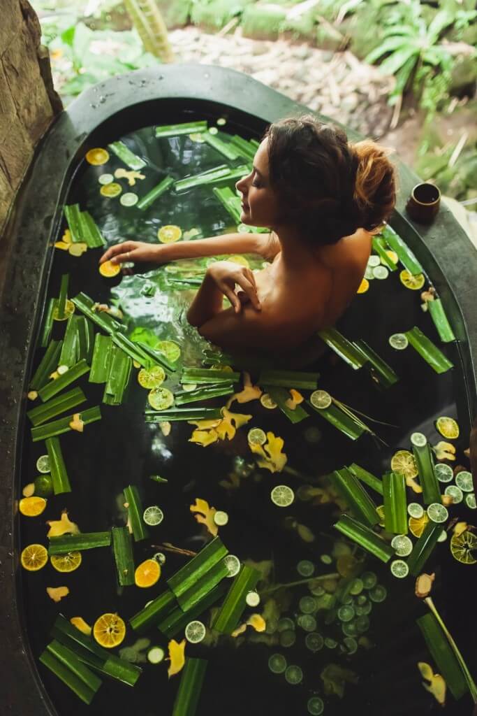 beautiful young woman enjoying in outdoor spa. luxury stone bath