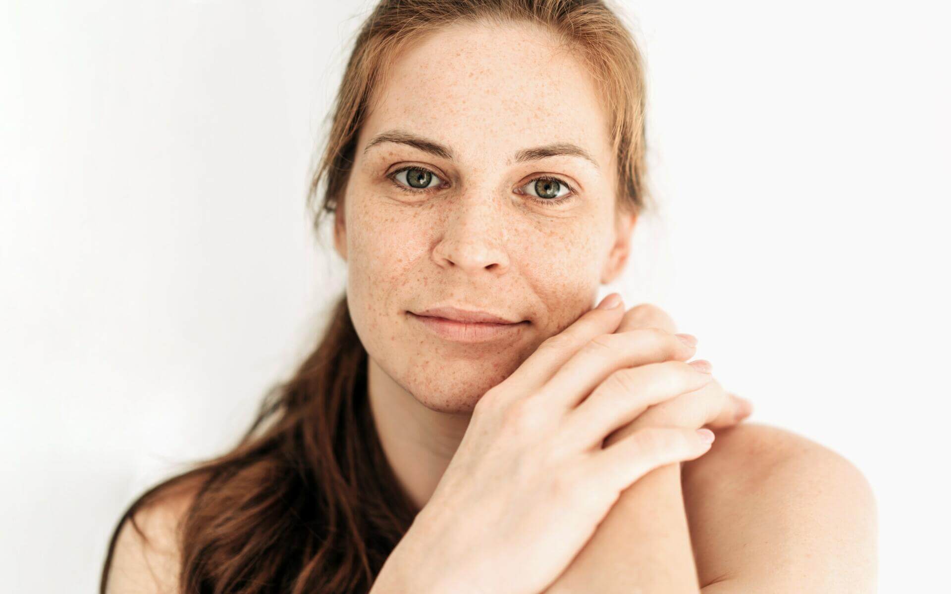 close up portrait of a natural redhead woman on a white background. natural authentic beauty.