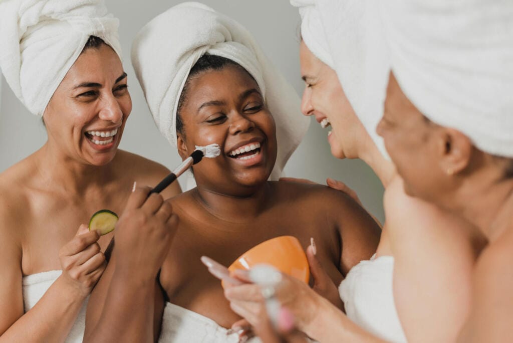 black woman applying clay mask near happy girlfrie 2023 11 27 05 22 22 utc