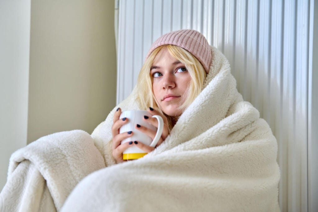 young female teenager warming herself with blanket 2023 11 27 05 02 28 utc