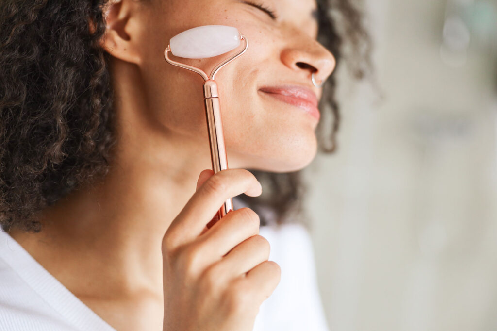 woman using facial roller on face focusing on jaw 2025 01 21 22 23 03 utc