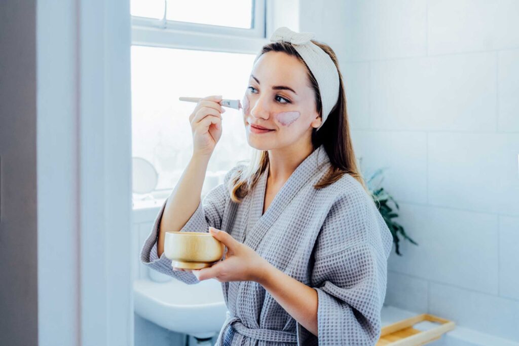 young woman in bathrobe looking in the mirror and 2025 02 12 19 25 51 utc